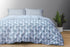 A king size bed sheet set with pillow covers displayed on a bed, featuring a geometric pattern in blue and white colors.